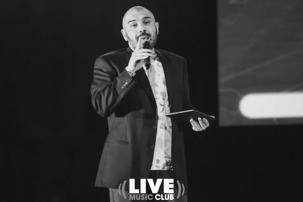 Edoardo Resta al microfono, in bianco e nero
